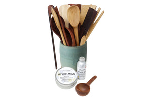 Set of wooden utensils in a container with wood care products on a white background